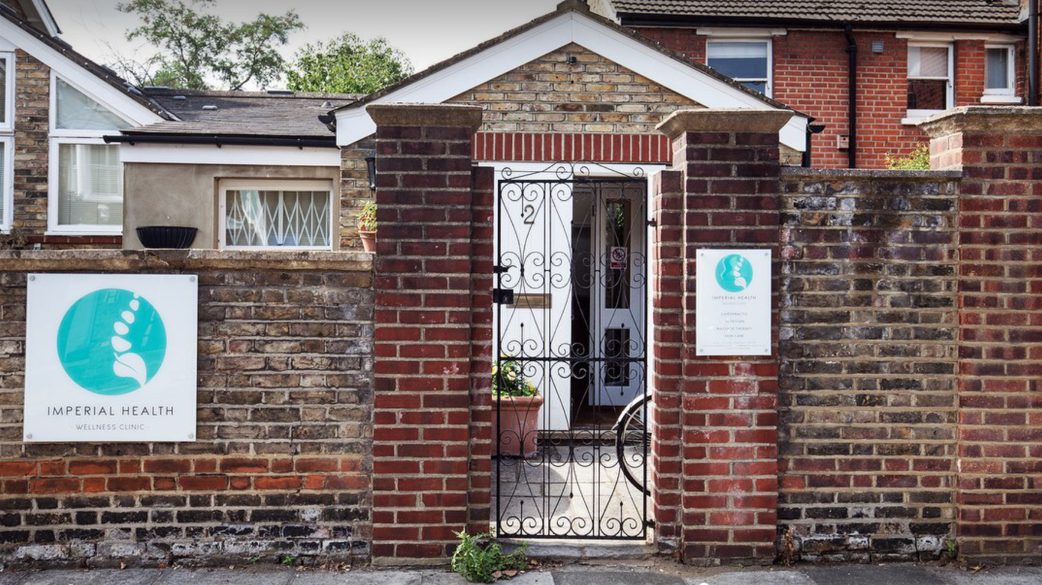 The clinic entrance on Larkfield Road: a brick porch with an iron gate, and two Imperial Health signs mounted on the wall.